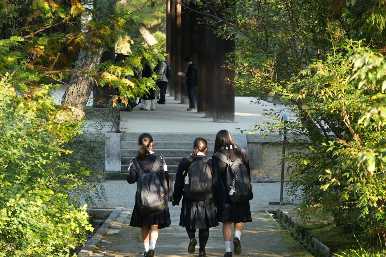 Estudiantes con uniforme caminando juntas hacia su colegio
